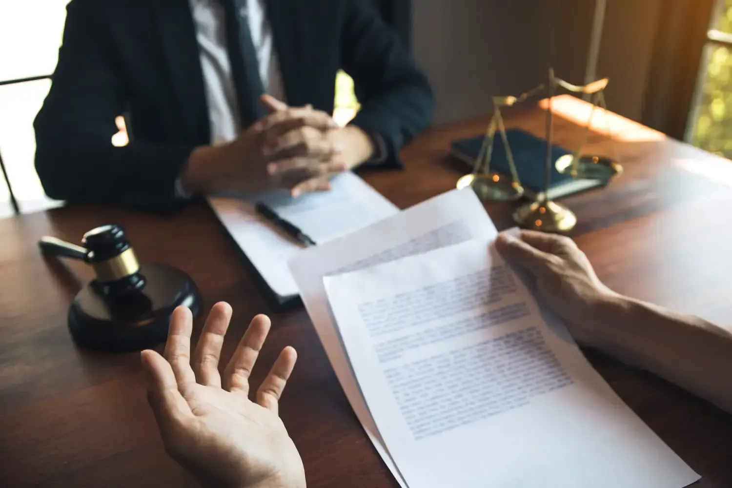 A man and a woman are sitting at a table with papers and a gavel.