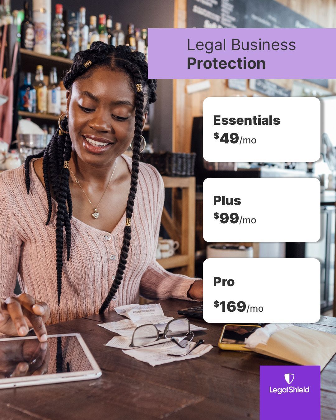 A woman is sitting at a table using a tablet.