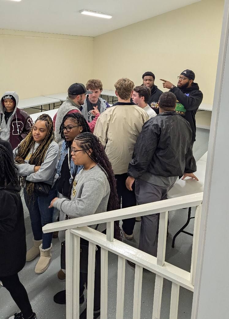 A group of people are standing around a table in a room.