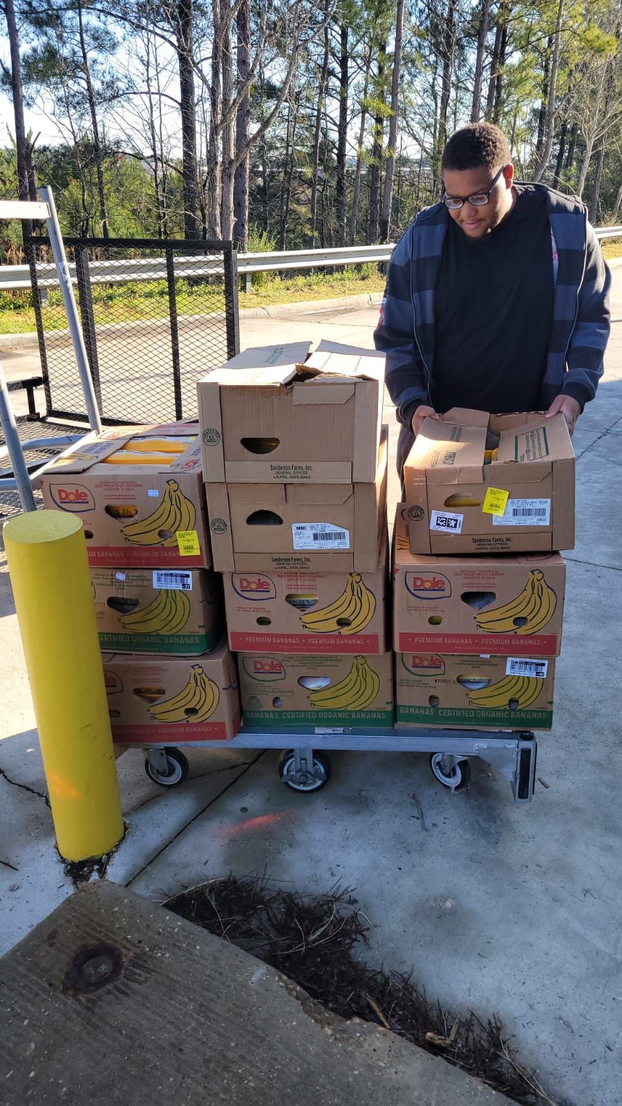 A man is loading boxes onto a cart.