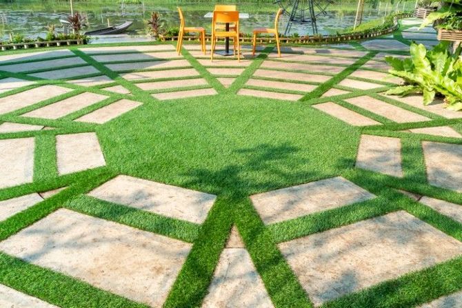 Circular stone-and-grass garden path with a wooden bench and greenery in the background