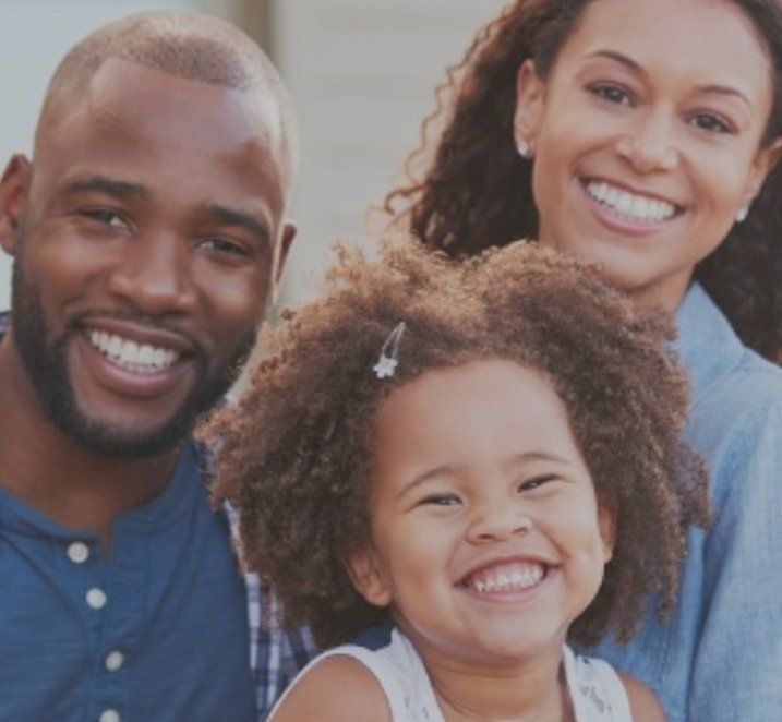 man, woman, and child smiling family dentist Fayetteville, NC
