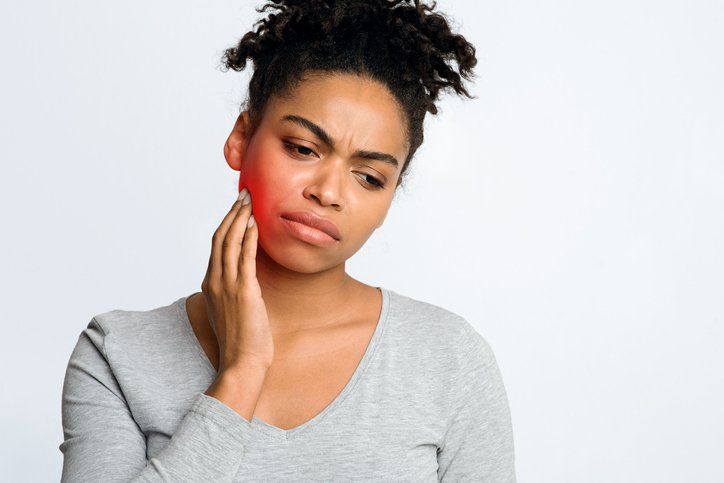 Young Woman Suffering With Toothache Touching Jaw