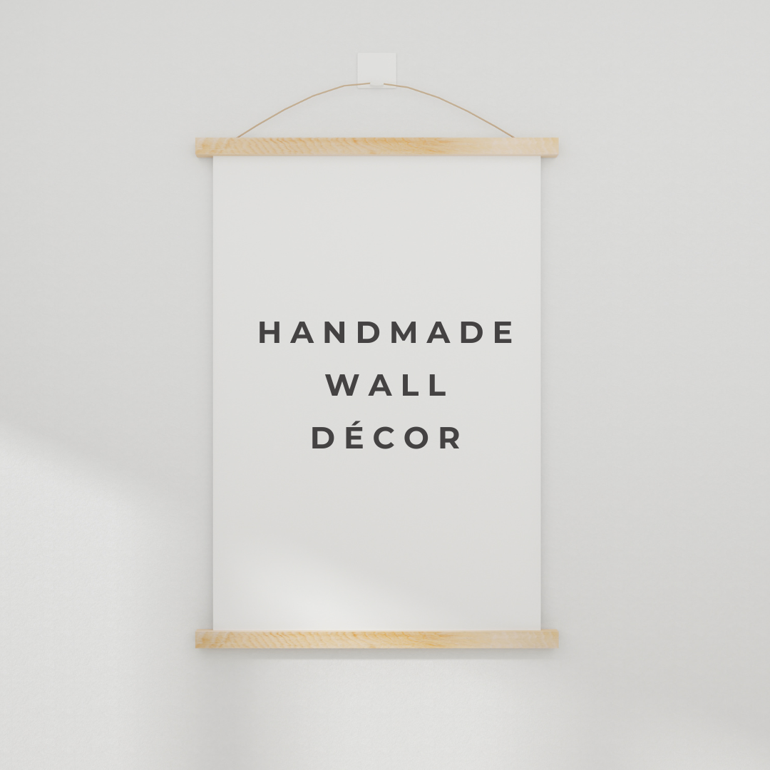 A handmade wall decor sign hangs on a white wall