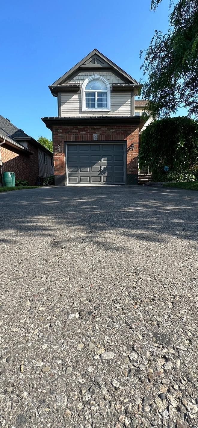 A house with a garage and a driveway in front of it.