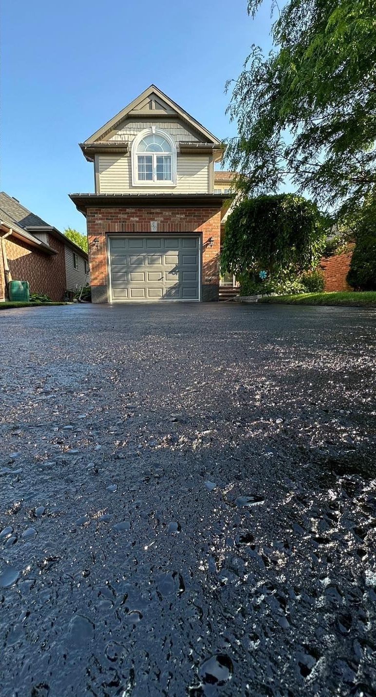 A house with a garage and a driveway in front of it.