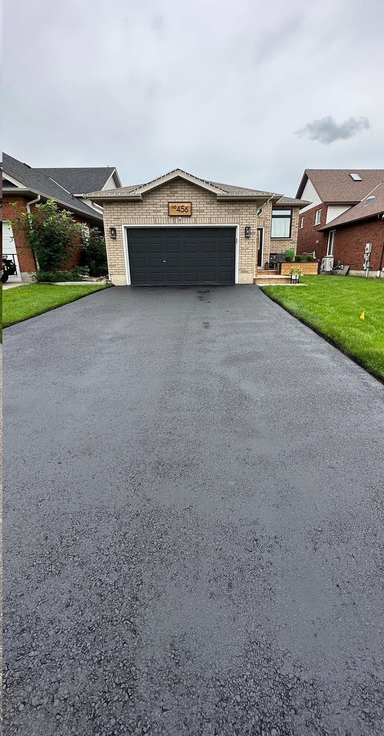 A driveway leading to a house with a large garage.