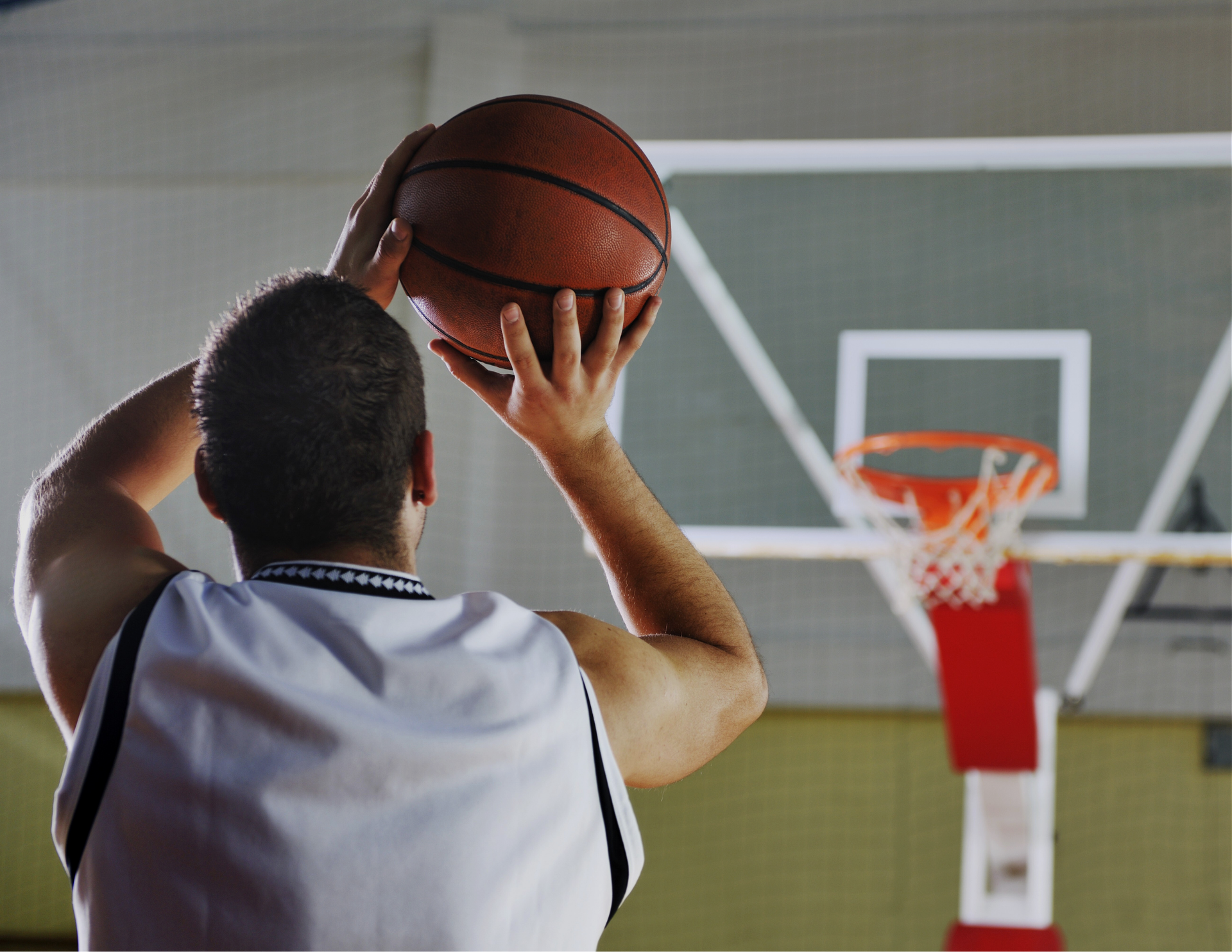 Person shooting basketball into hoop