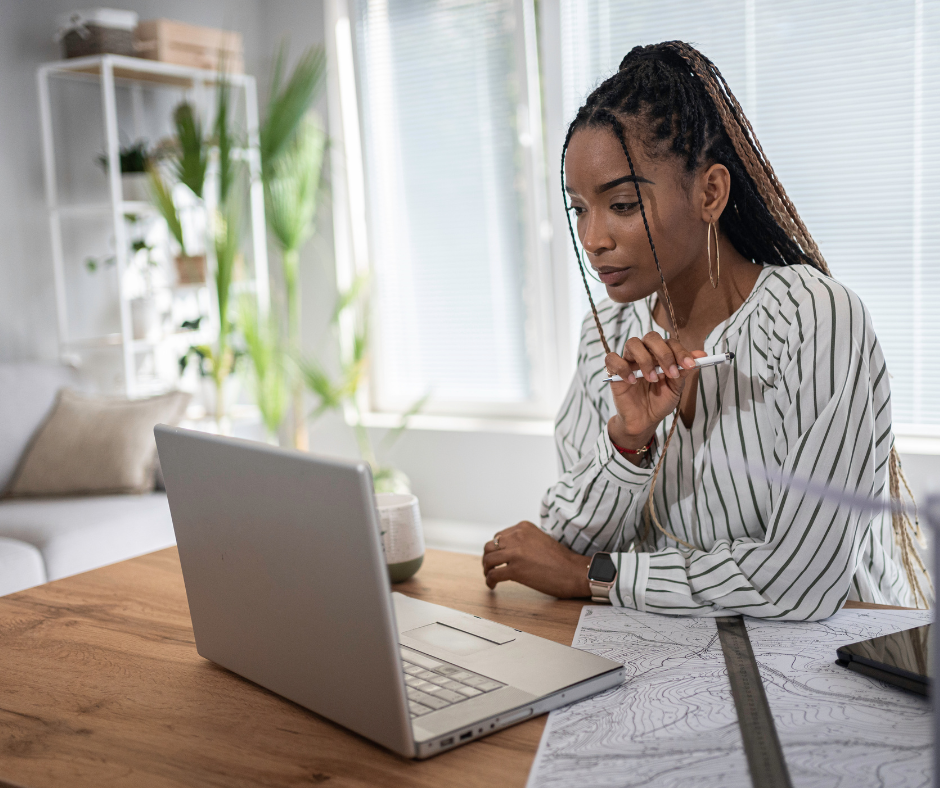 Woman holding pencil shopping on laptop