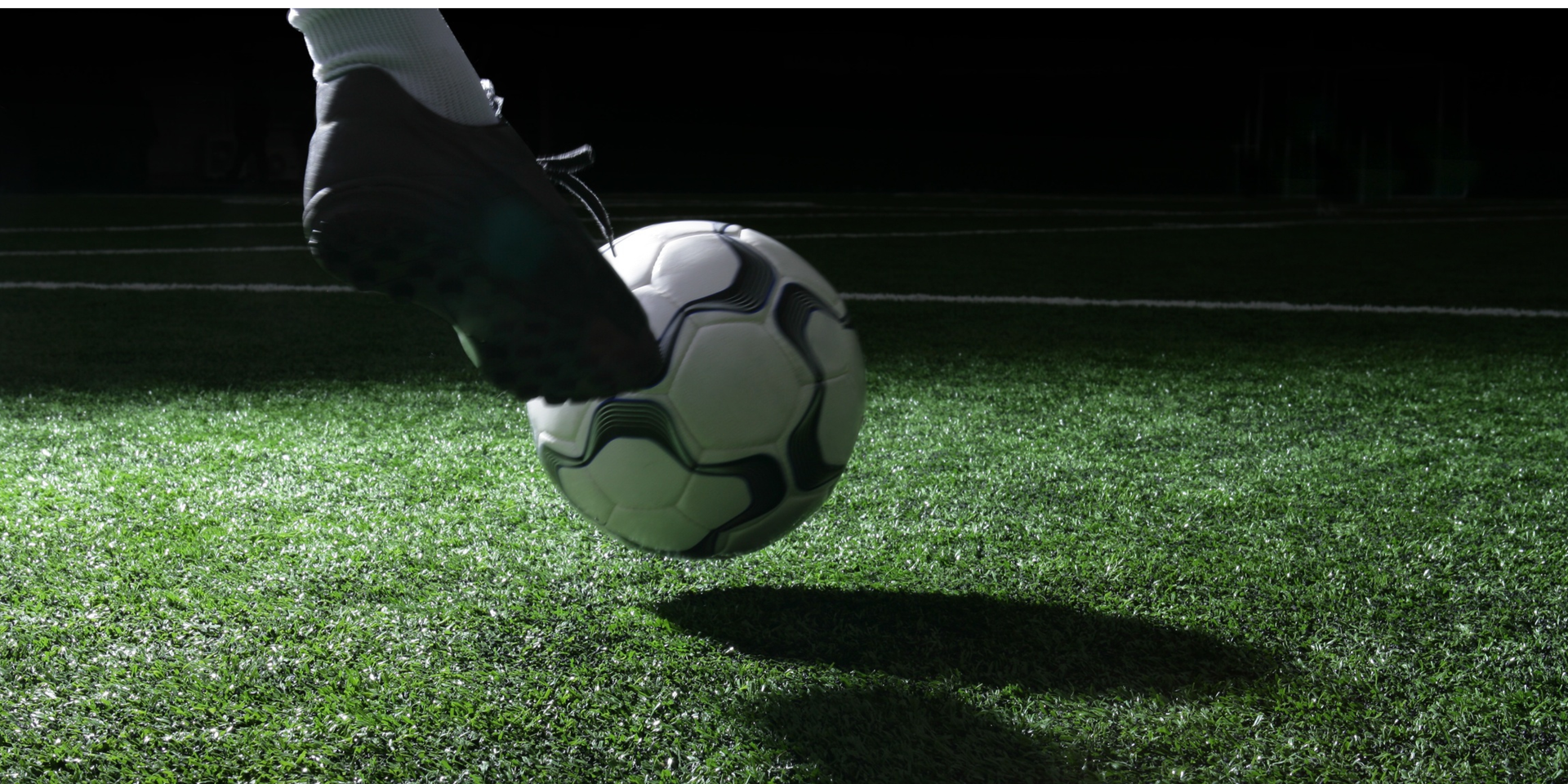 A soccer ball getting kicked at a goal