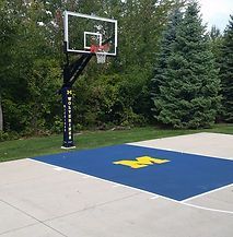 A basketball court with a basketball hoop and a blue and yellow floor.