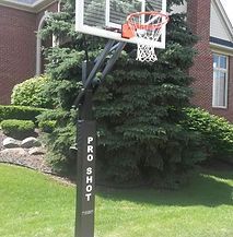 A basketball hoop is sitting in front of a brick house.