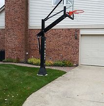 A basketball hoop is sitting in front of a brick house.