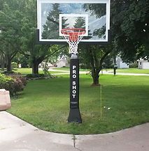 A basketball hoop is sitting in the middle of a park.