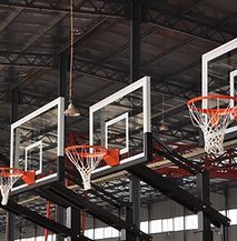 A row of basketball hoops hanging from the ceiling of a gym.