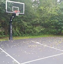 There is a basketball hoop in the middle of a basketball court.
