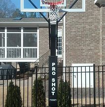 A basketball hoop is sitting in front of a brick house.