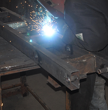 A man is welding a piece of metal with sparks coming out of it