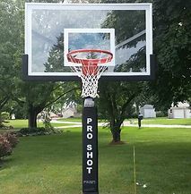 A basketball hoop is sitting in the middle of a park.