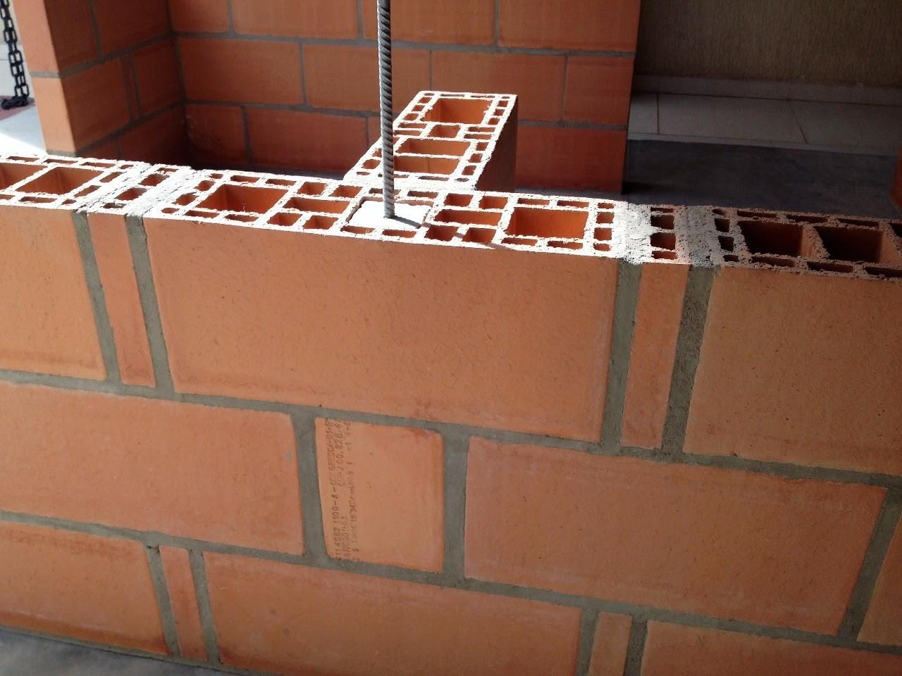 Uma parede de tijolos está sendo construída com uma viga no meio