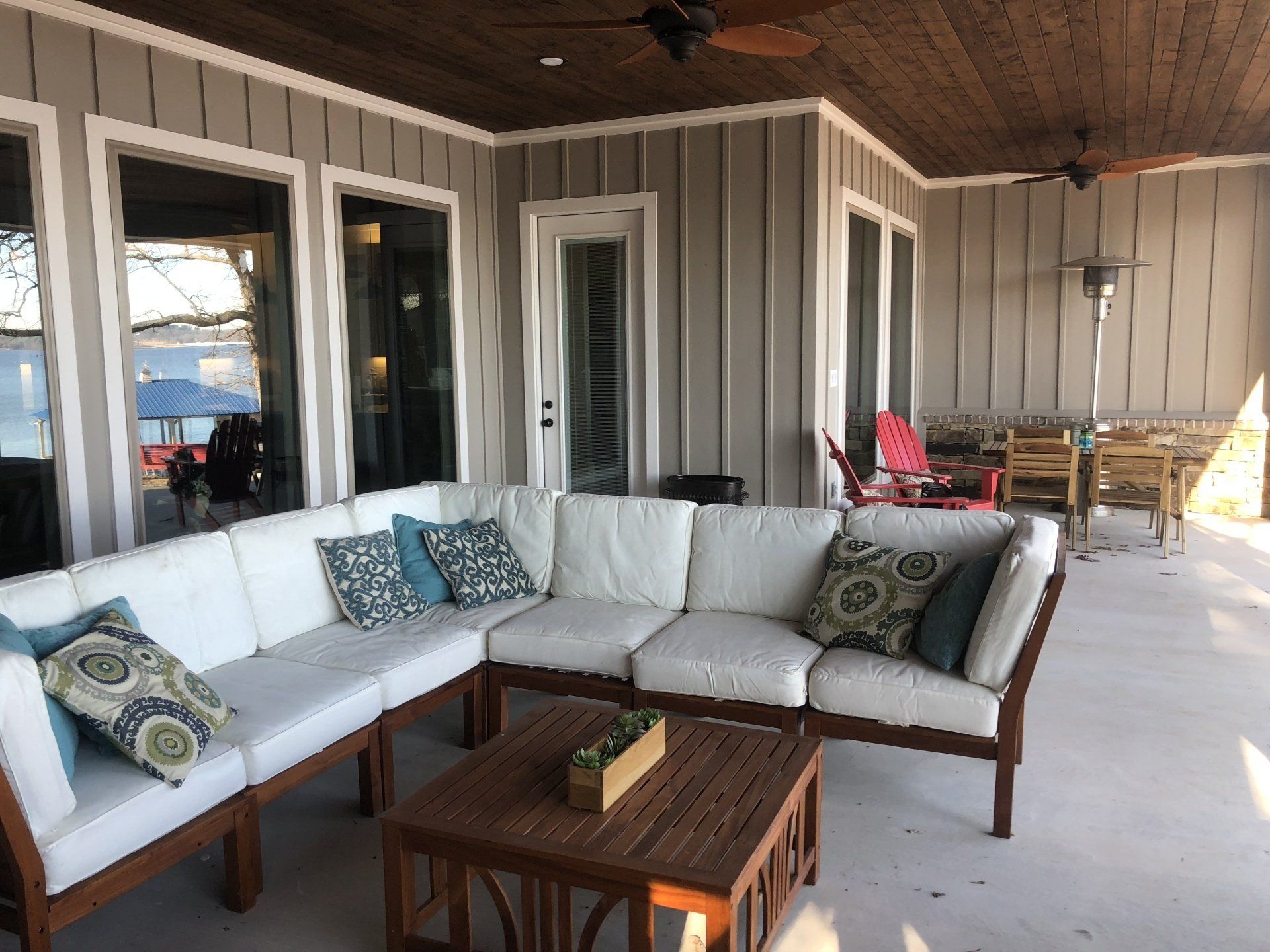 A patio with a large sectional couch and a coffee table