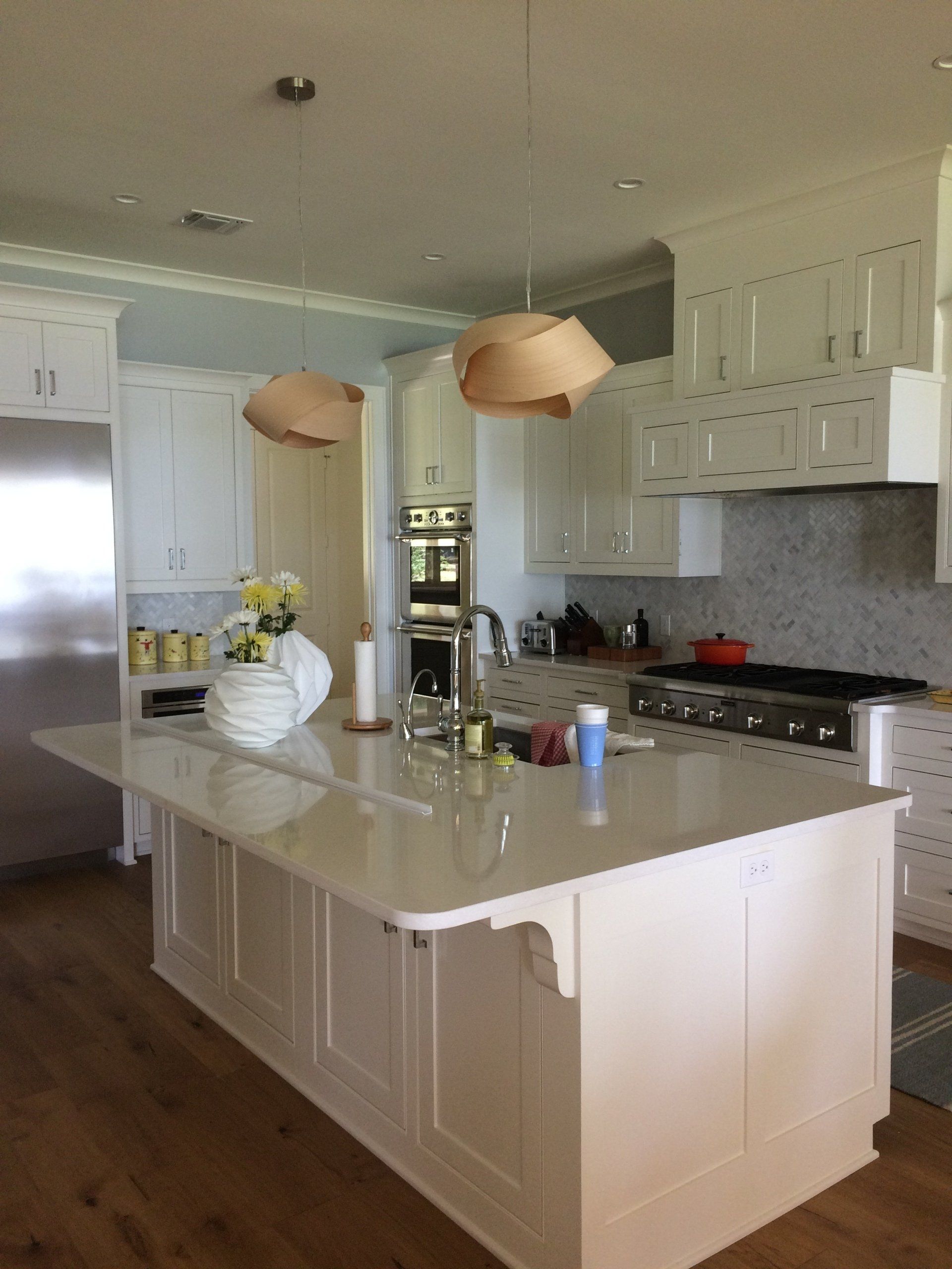 A kitchen with white cabinets and a large island