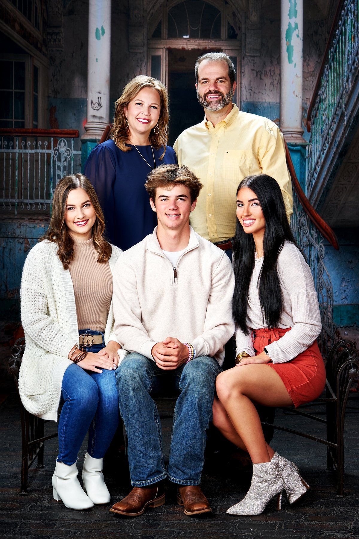 A family is posing for a picture in front of a building.