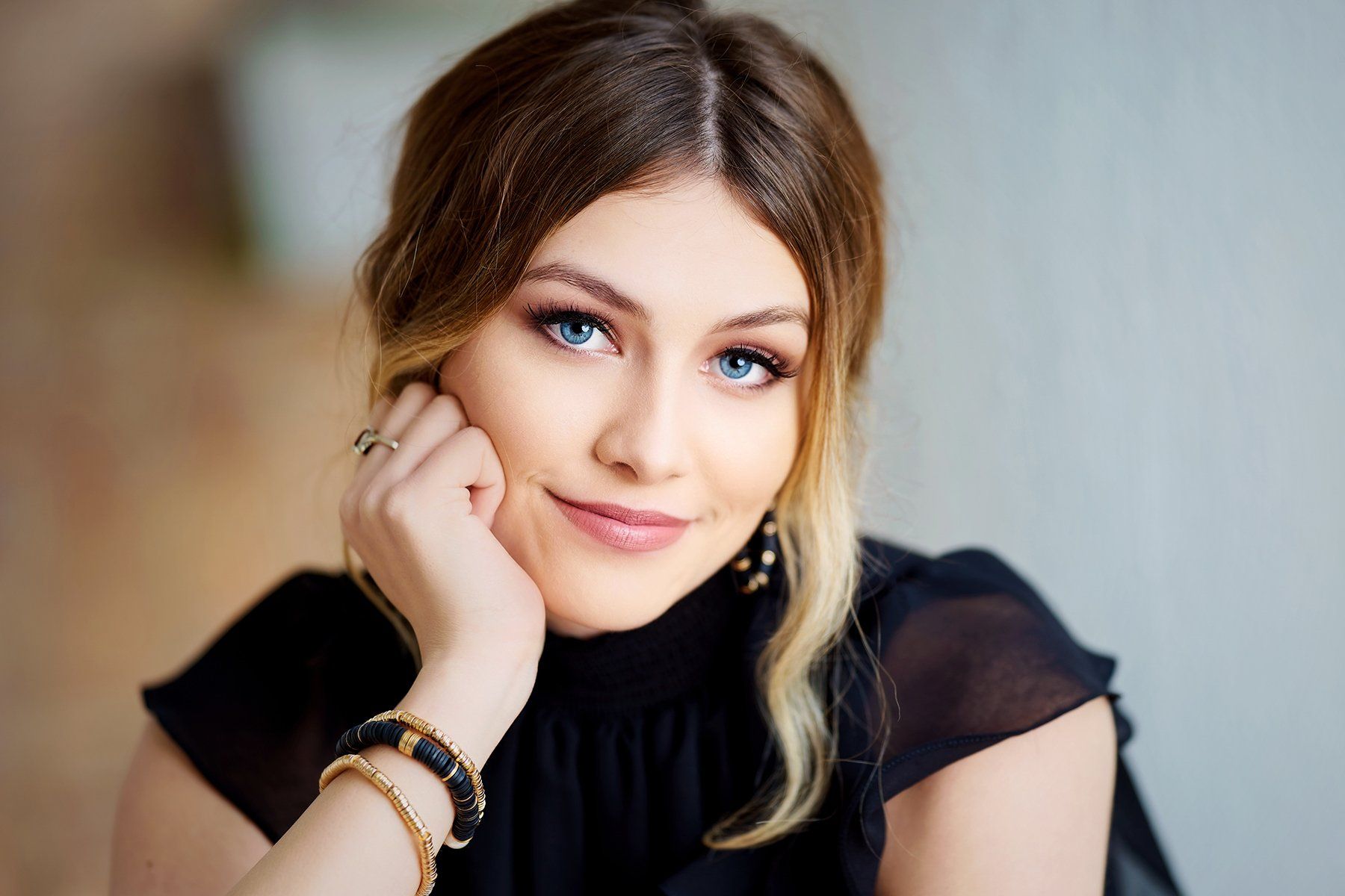 A close up of a woman 's face with her hand on her chin.