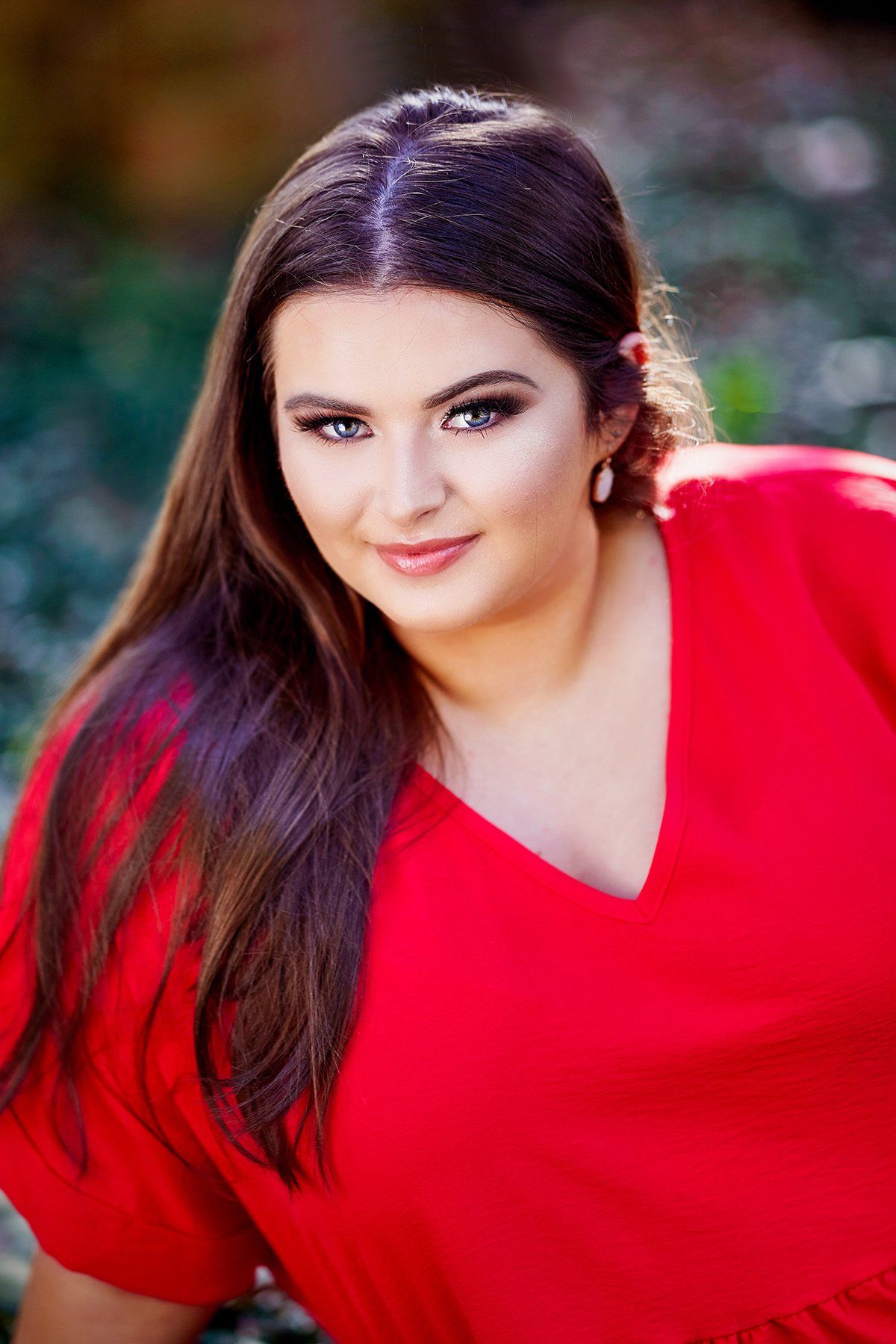 A woman in a red dress is posing for a picture.