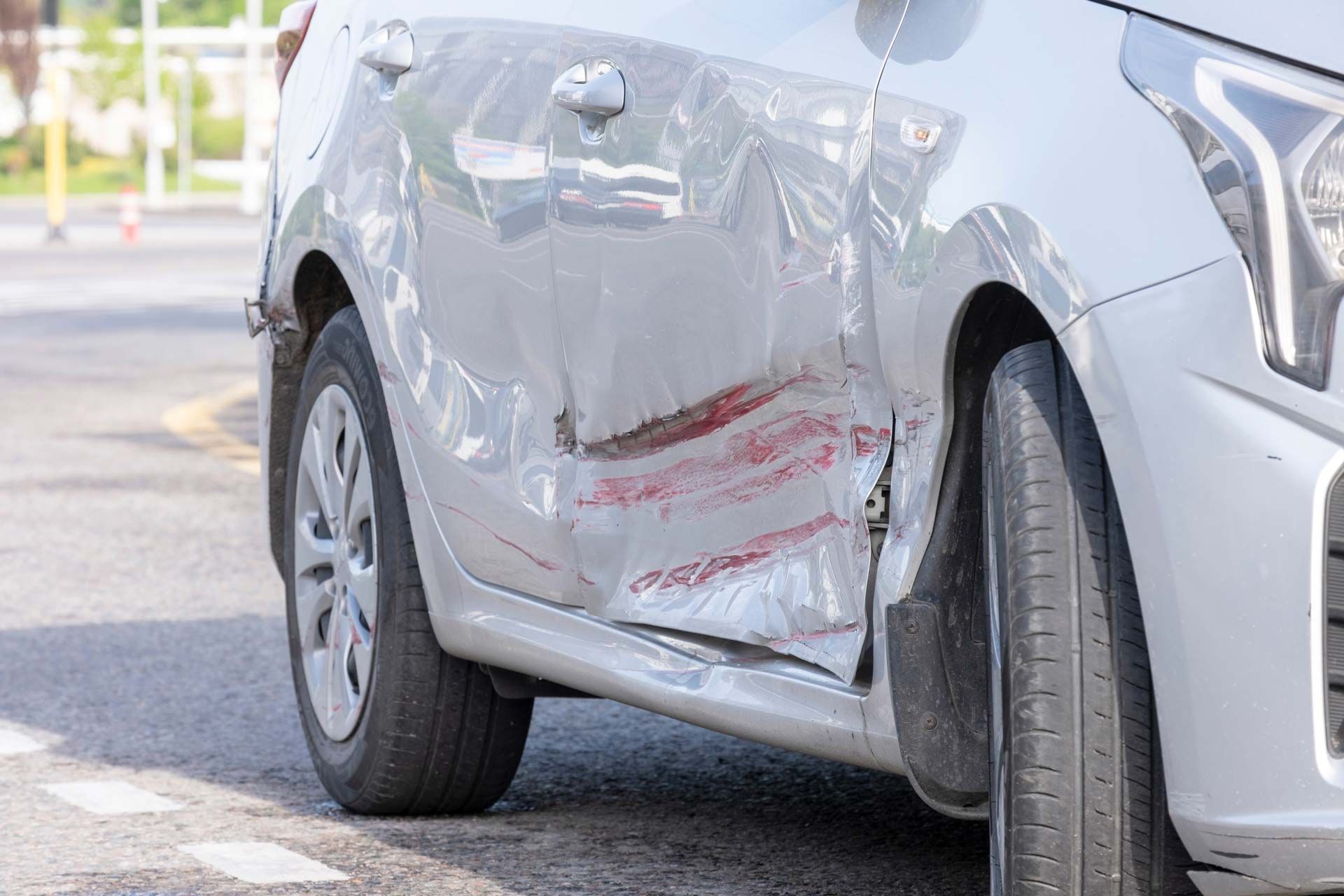 Silver car with severe damage to the side, likely from a collision.