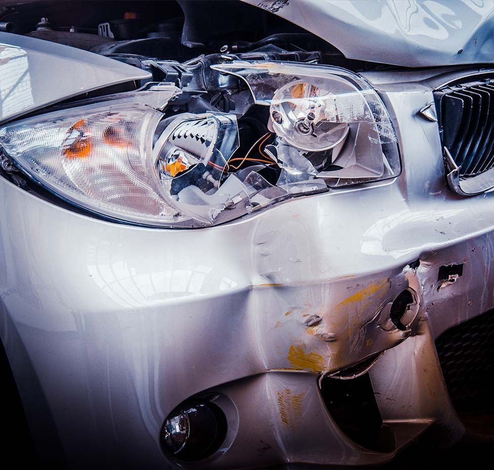 Damaged silver car, front end crumpled.