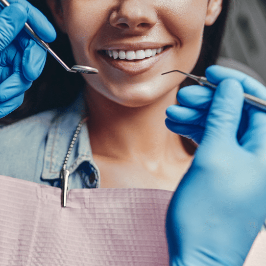 A woman is getting her teeth examined by a dentist