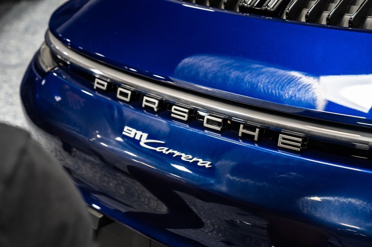 Close-up of a blue vehicle treated with premium ceramic coating layers.