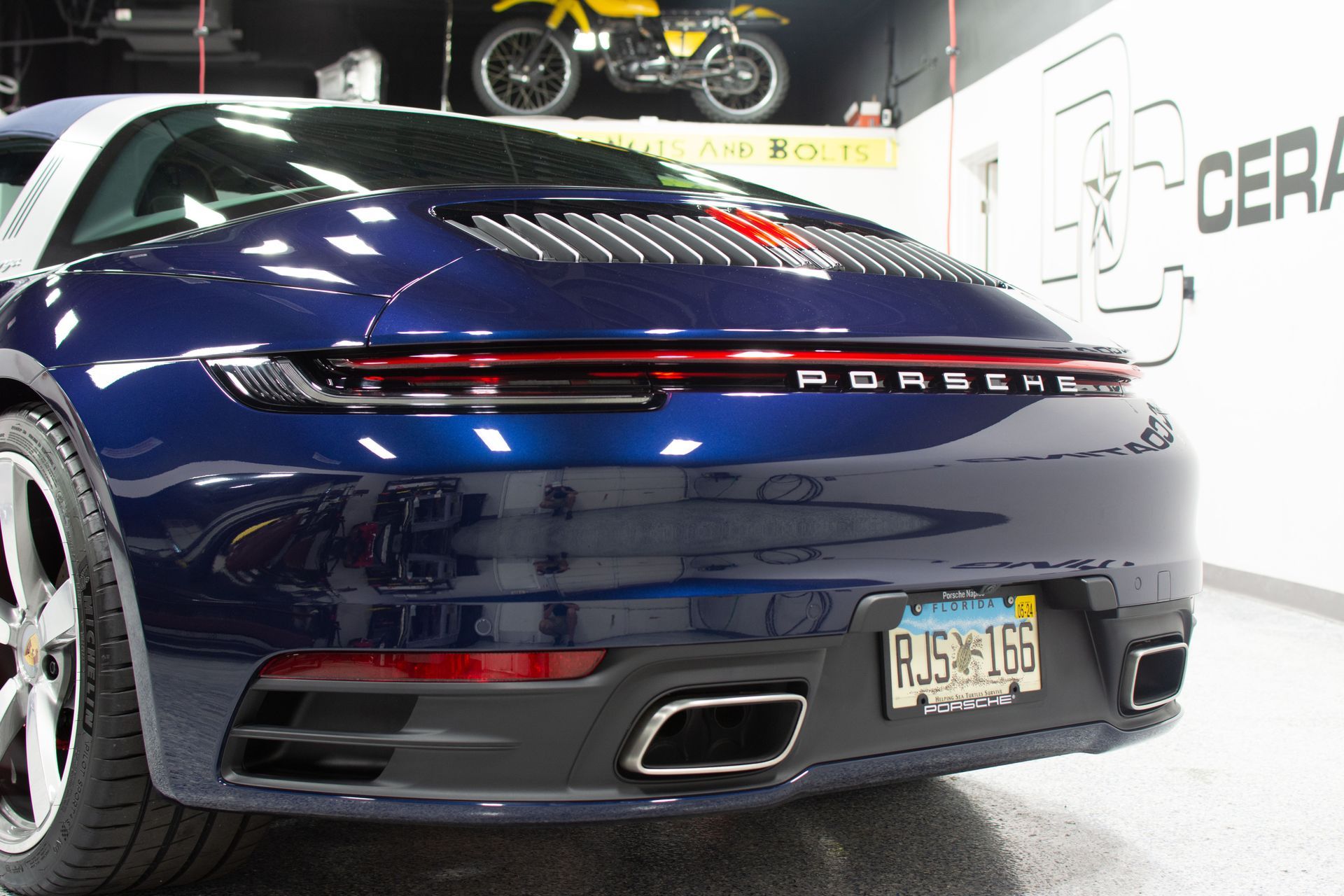 A blue Porsche is parked in a garage after a ceramic coating application