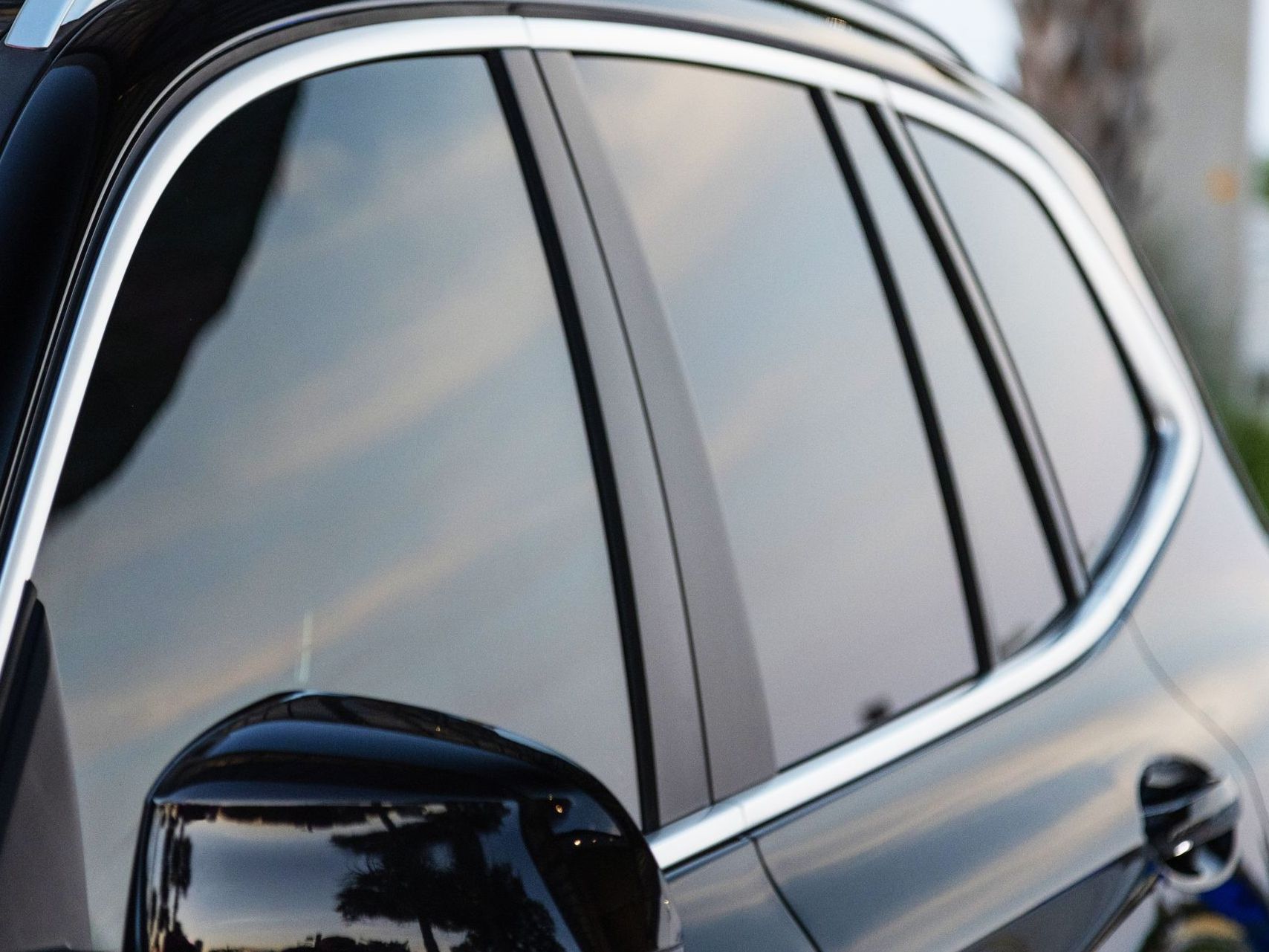 A close up of a car window with a chrome trim