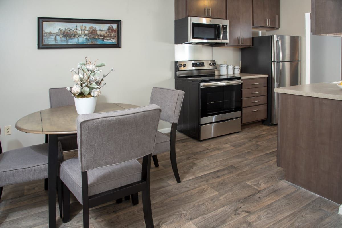 A kitchen with a table and chairs and a refrigerator.