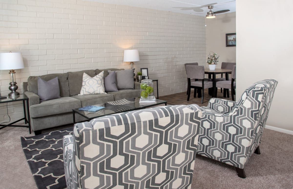 A living room with a couch , chairs , and a table.