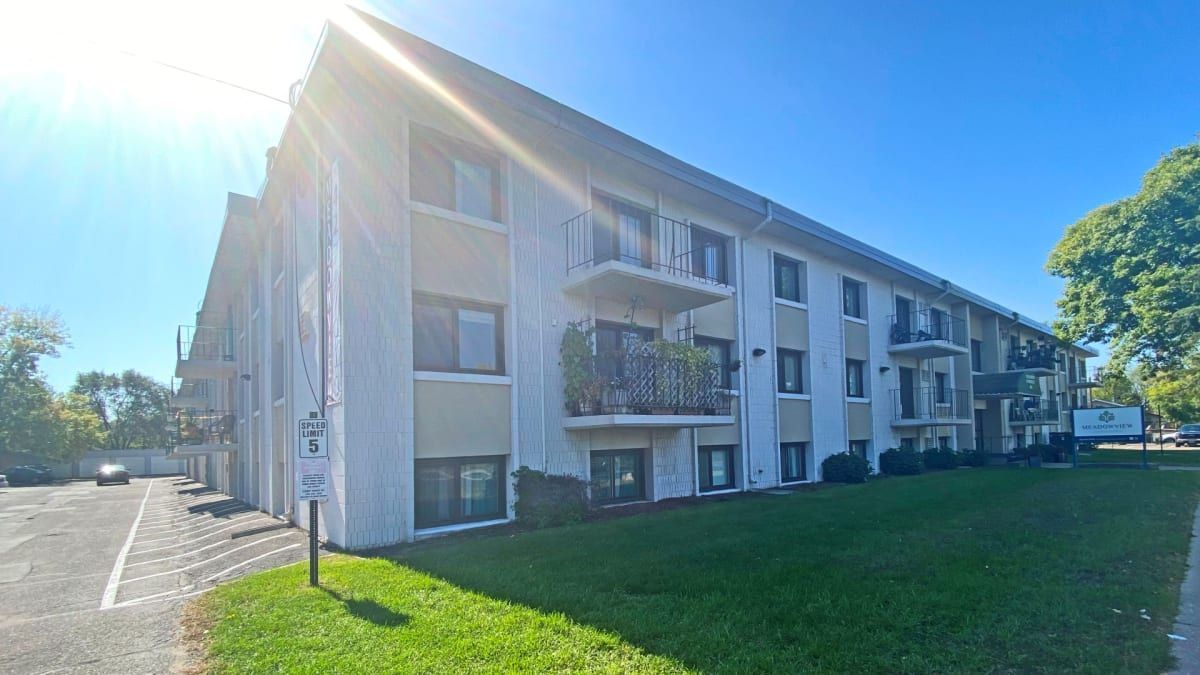 A large white apartment building with a lot of windows and balconies.