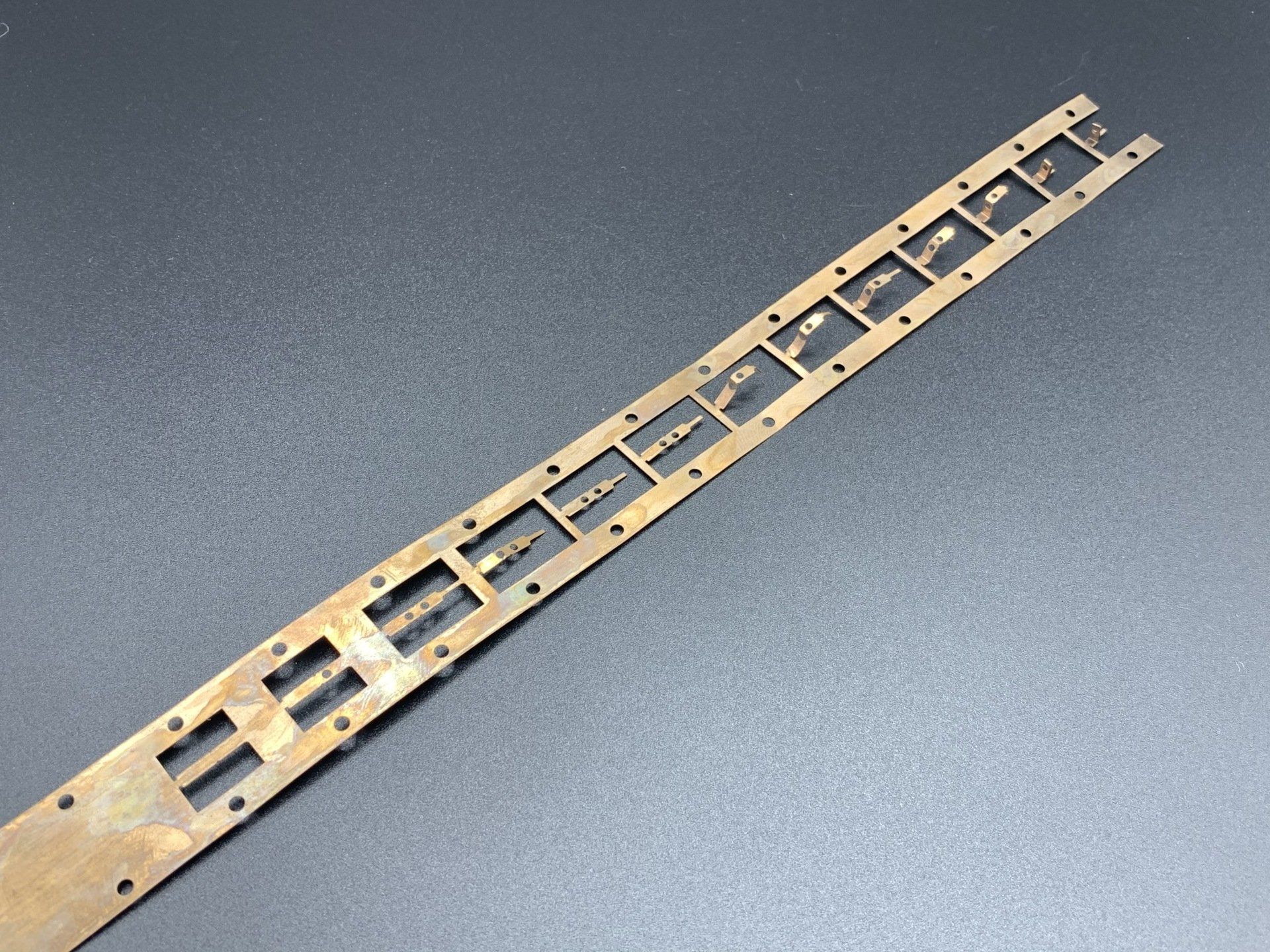 A piece of metal with holes in it is sitting on a table.