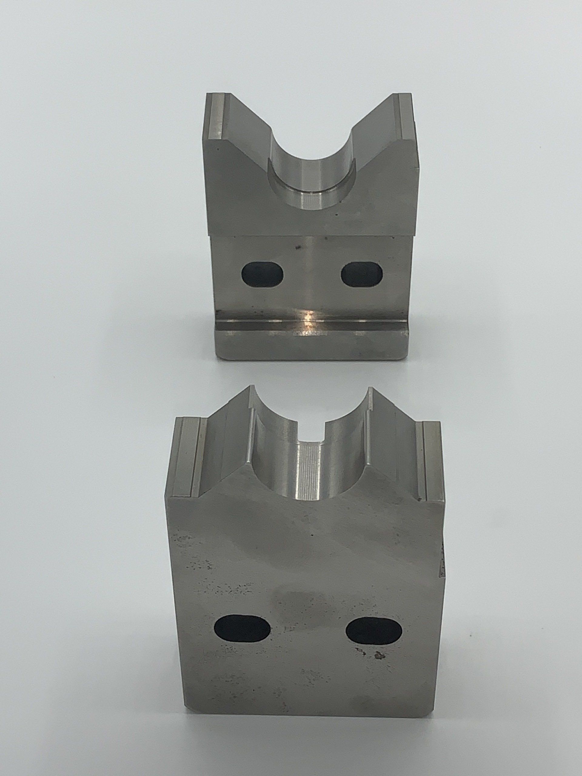 Two pieces of metal are sitting on top of each other on a white surface.