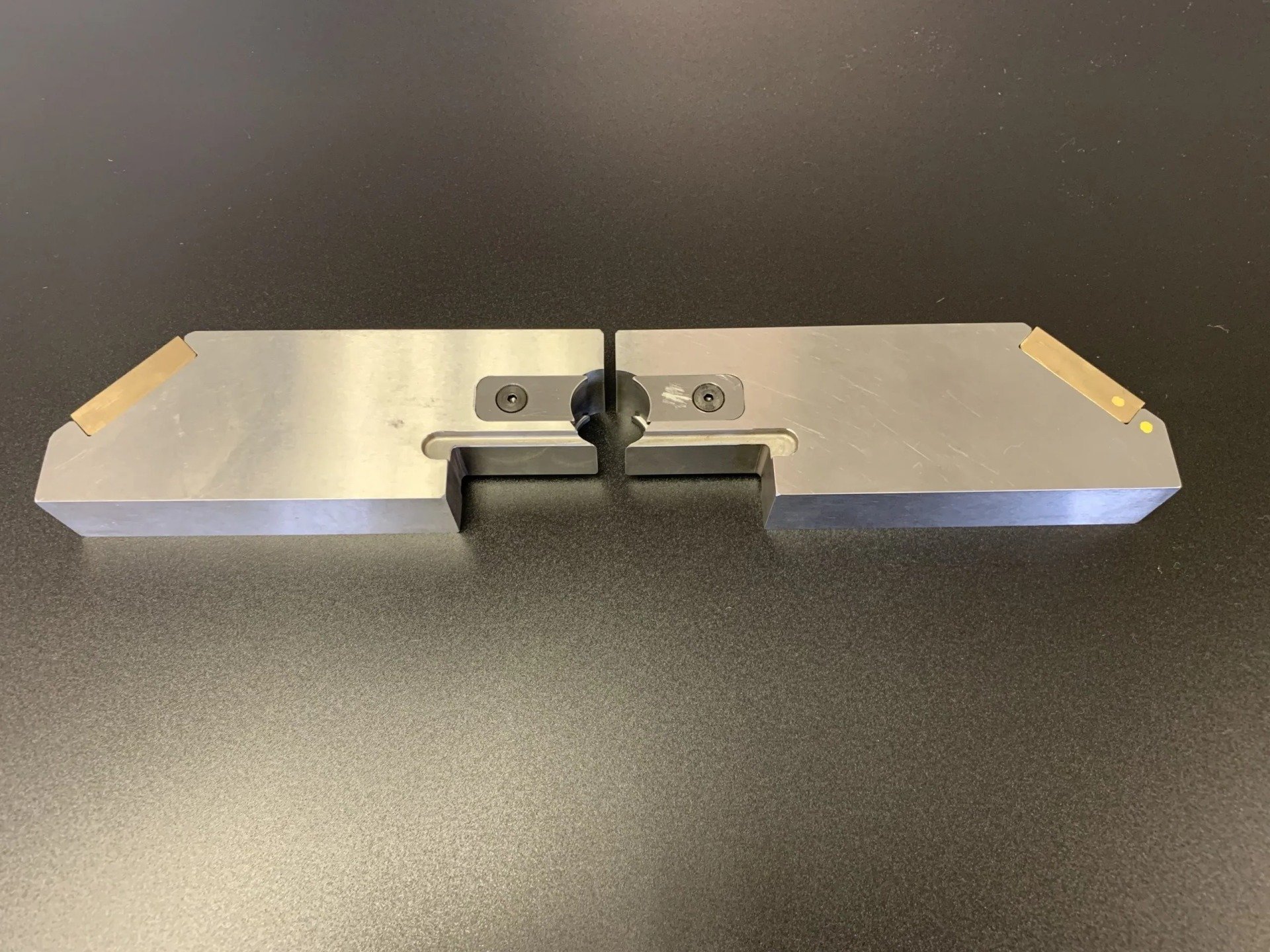 A piece of metal is sitting on top of a black table.