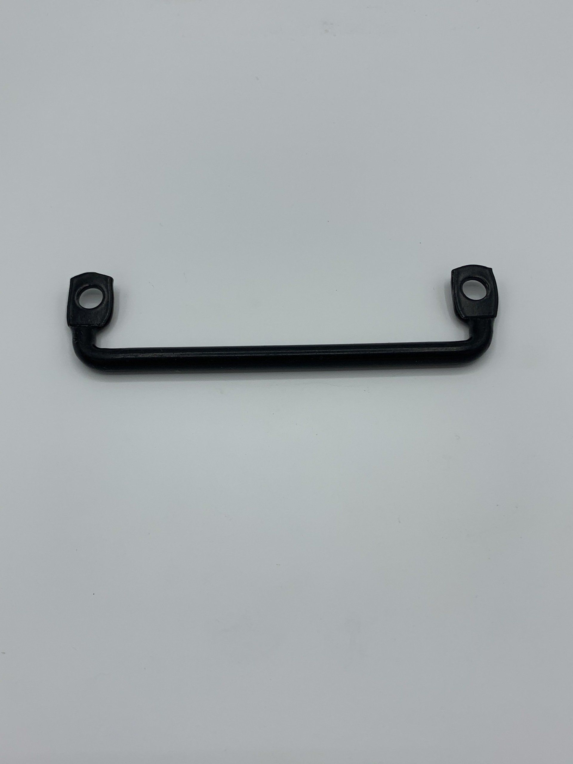 A black handle is sitting on a white surface.