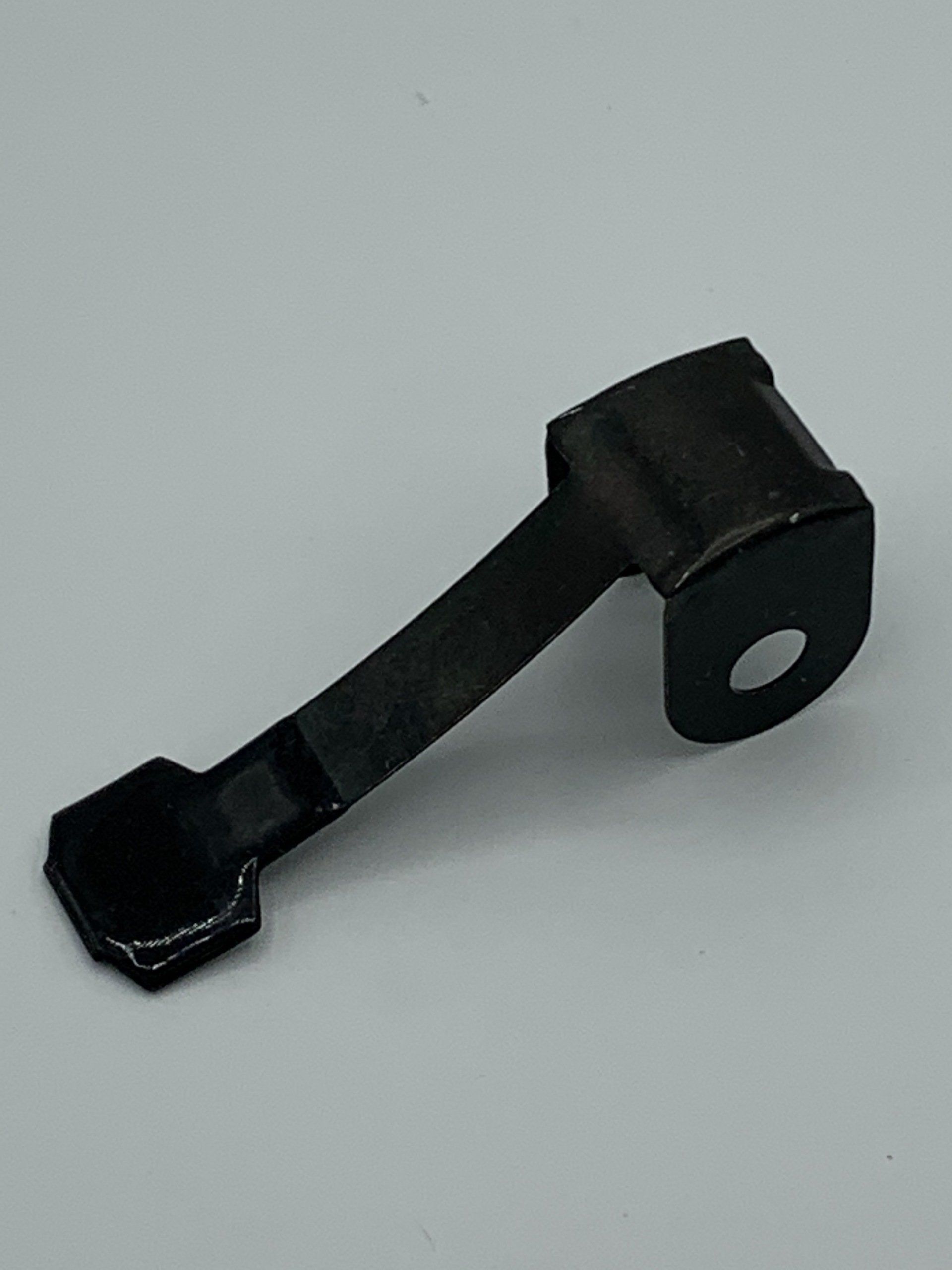 A black metal object is sitting on a white surface.