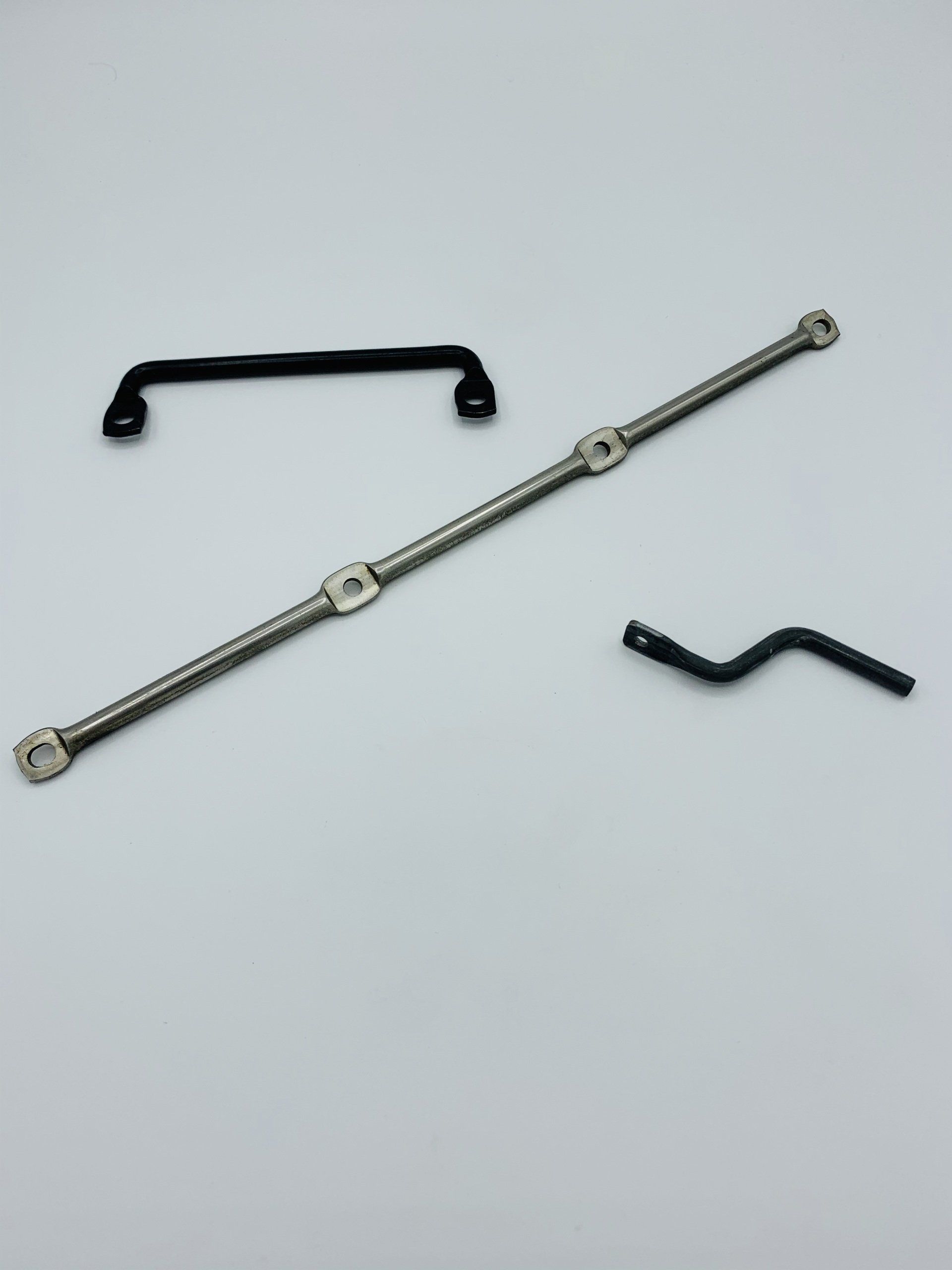 Three different types of handles are sitting on a white surface.