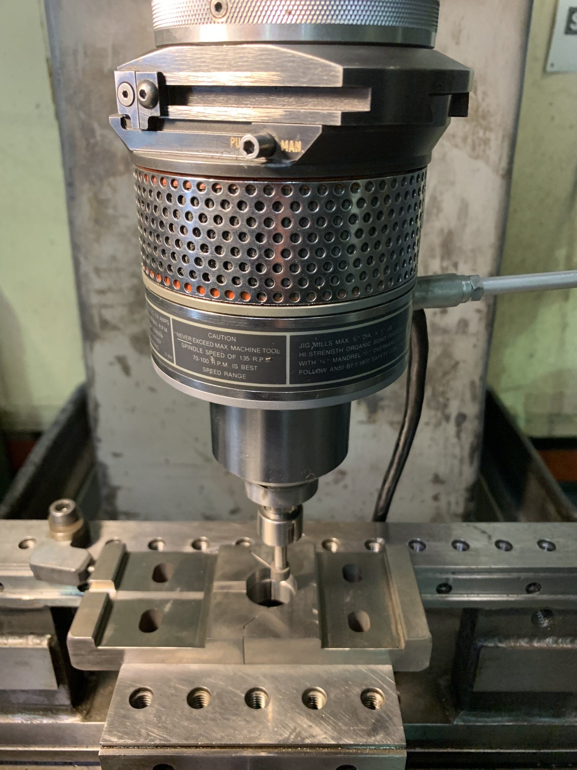 A machine is cutting a piece of metal on a table.