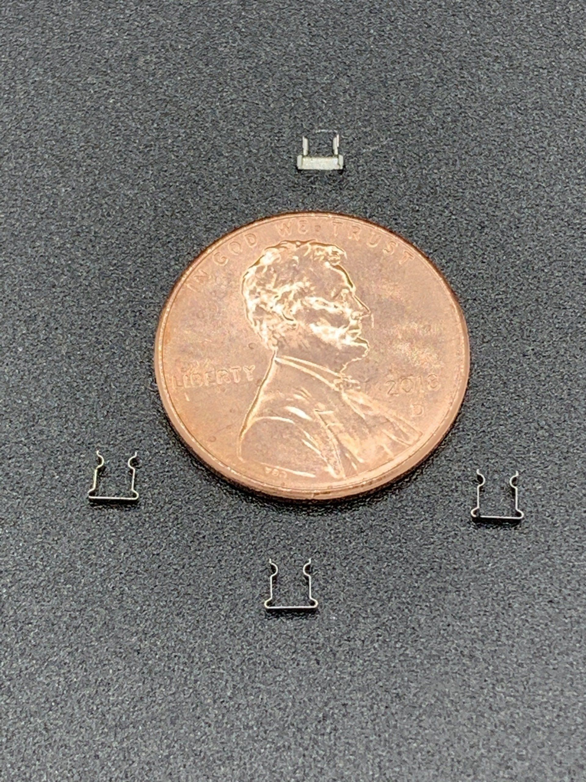 A penny is sitting on top of a black surface.