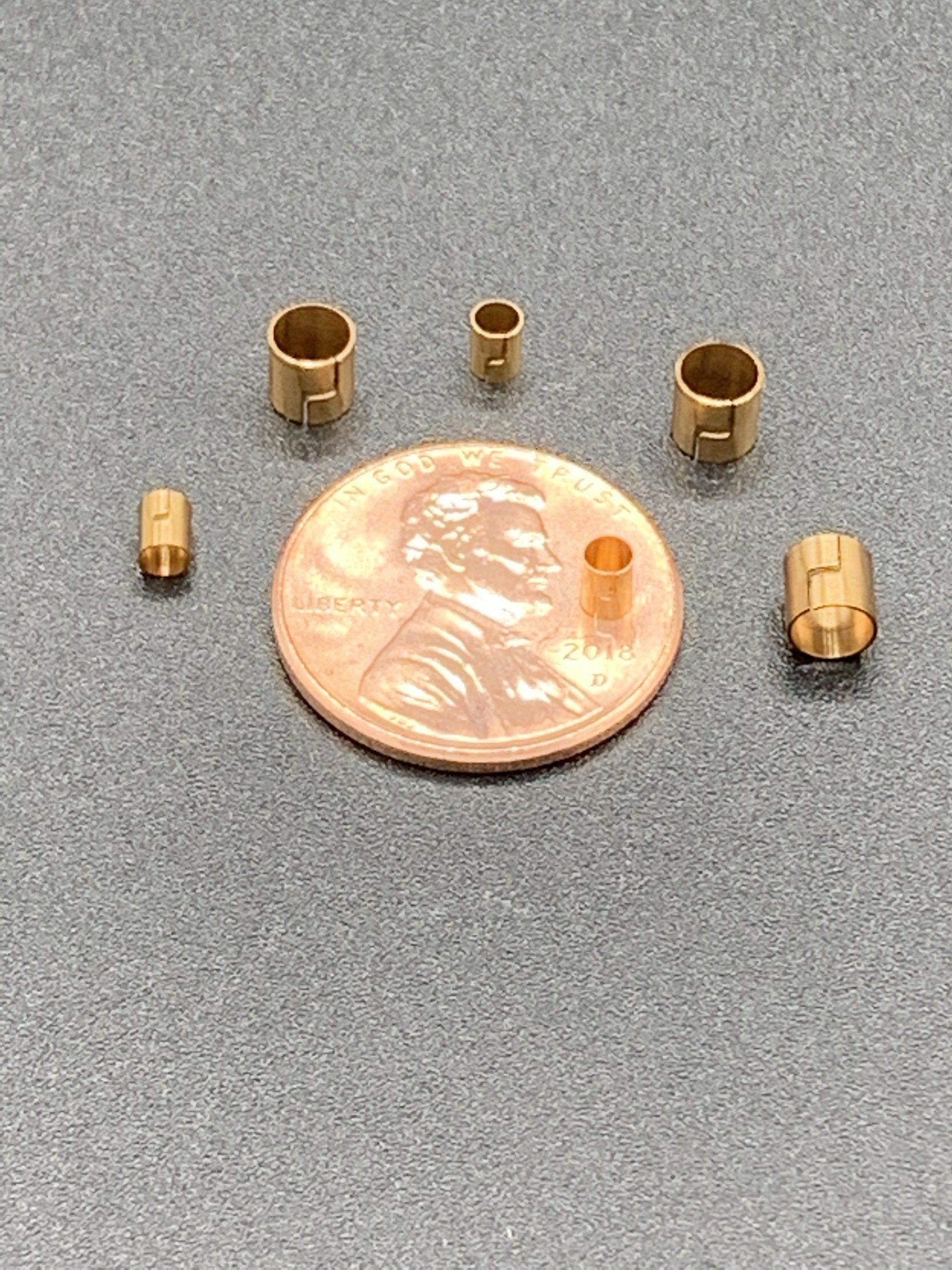 A penny is sitting on top of a table next to a bunch of small metal pieces.