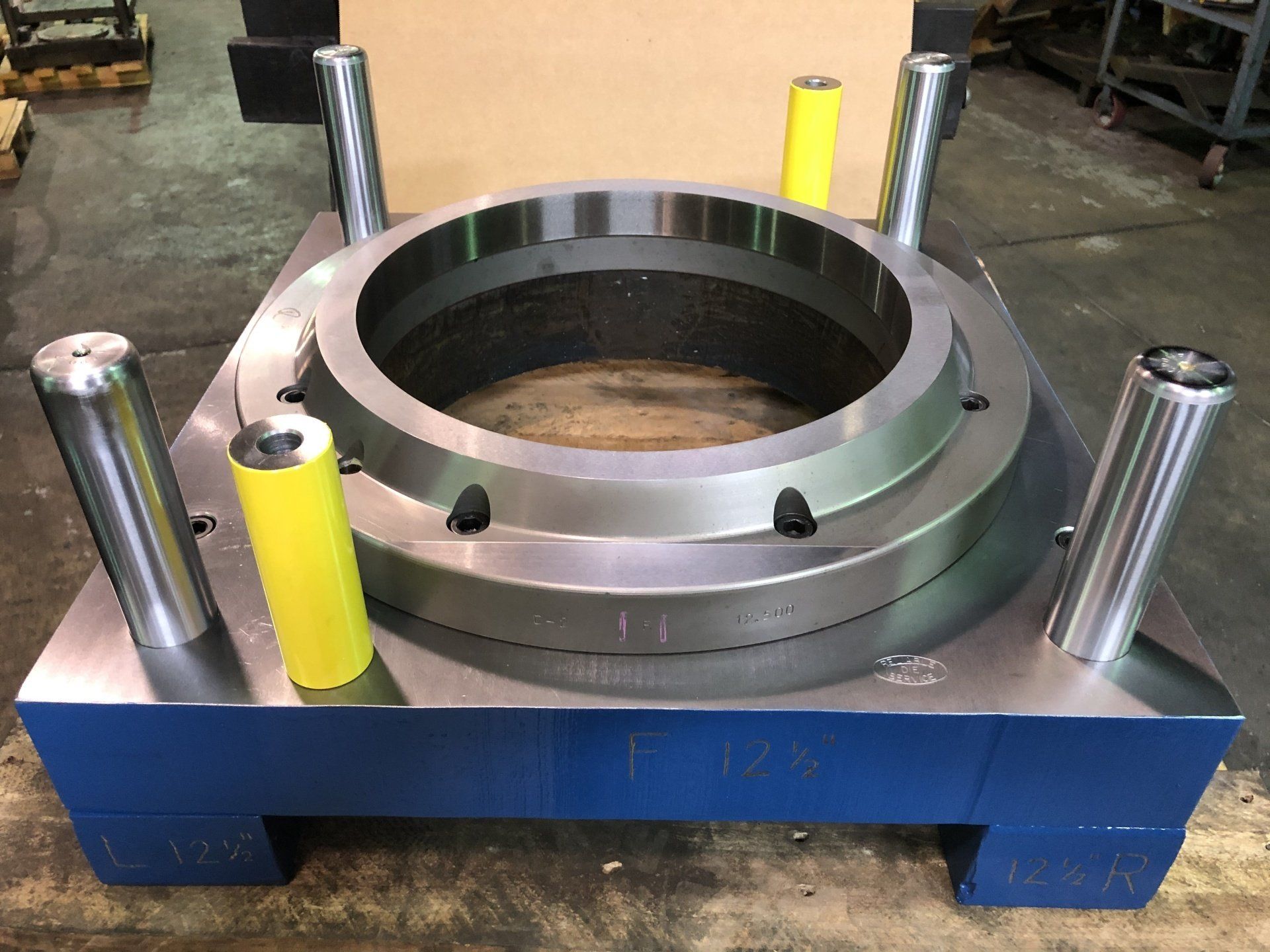 A large metal ring is sitting on top of a blue pallet.