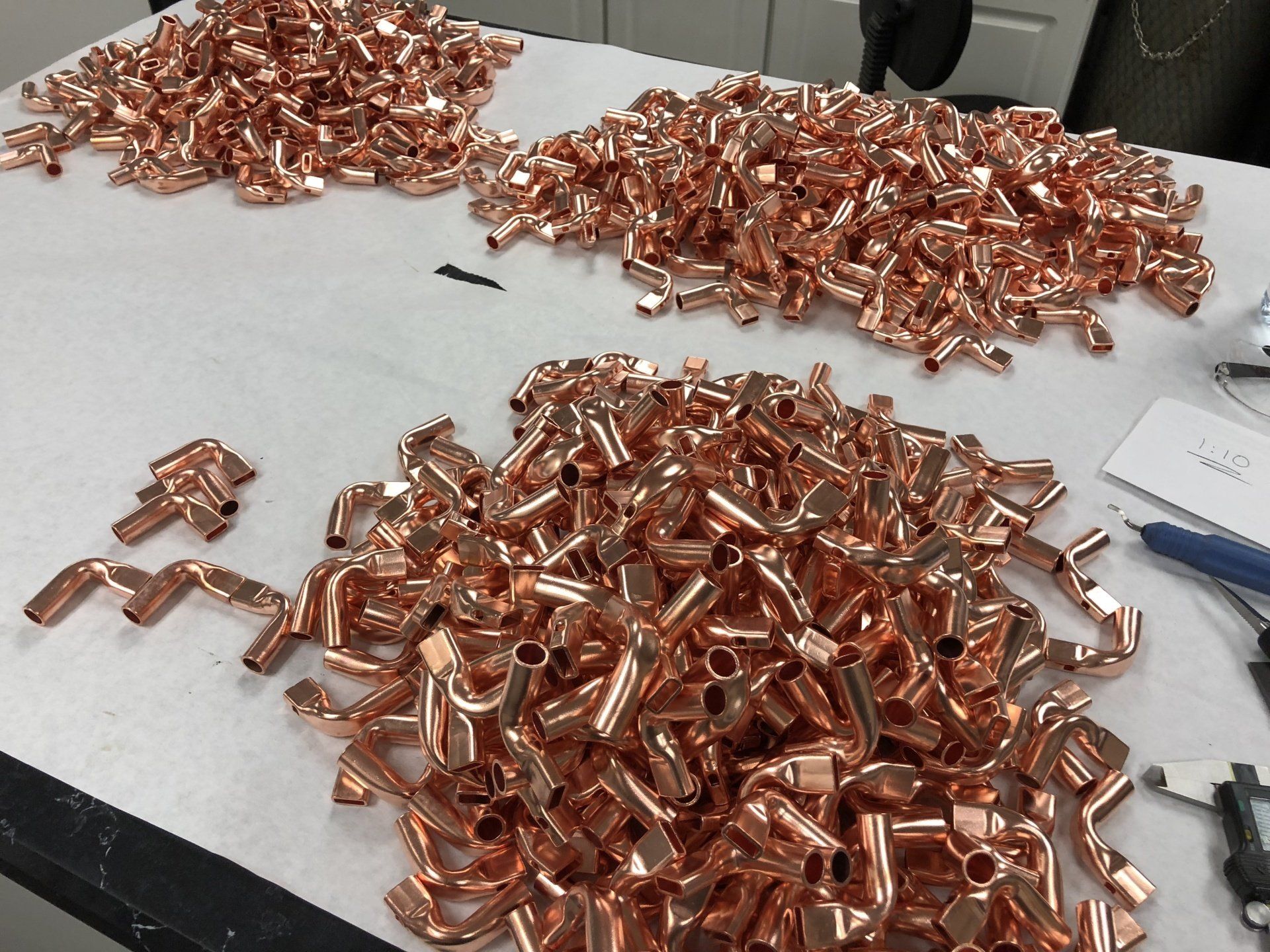 Two piles of copper pipes are sitting on a table
