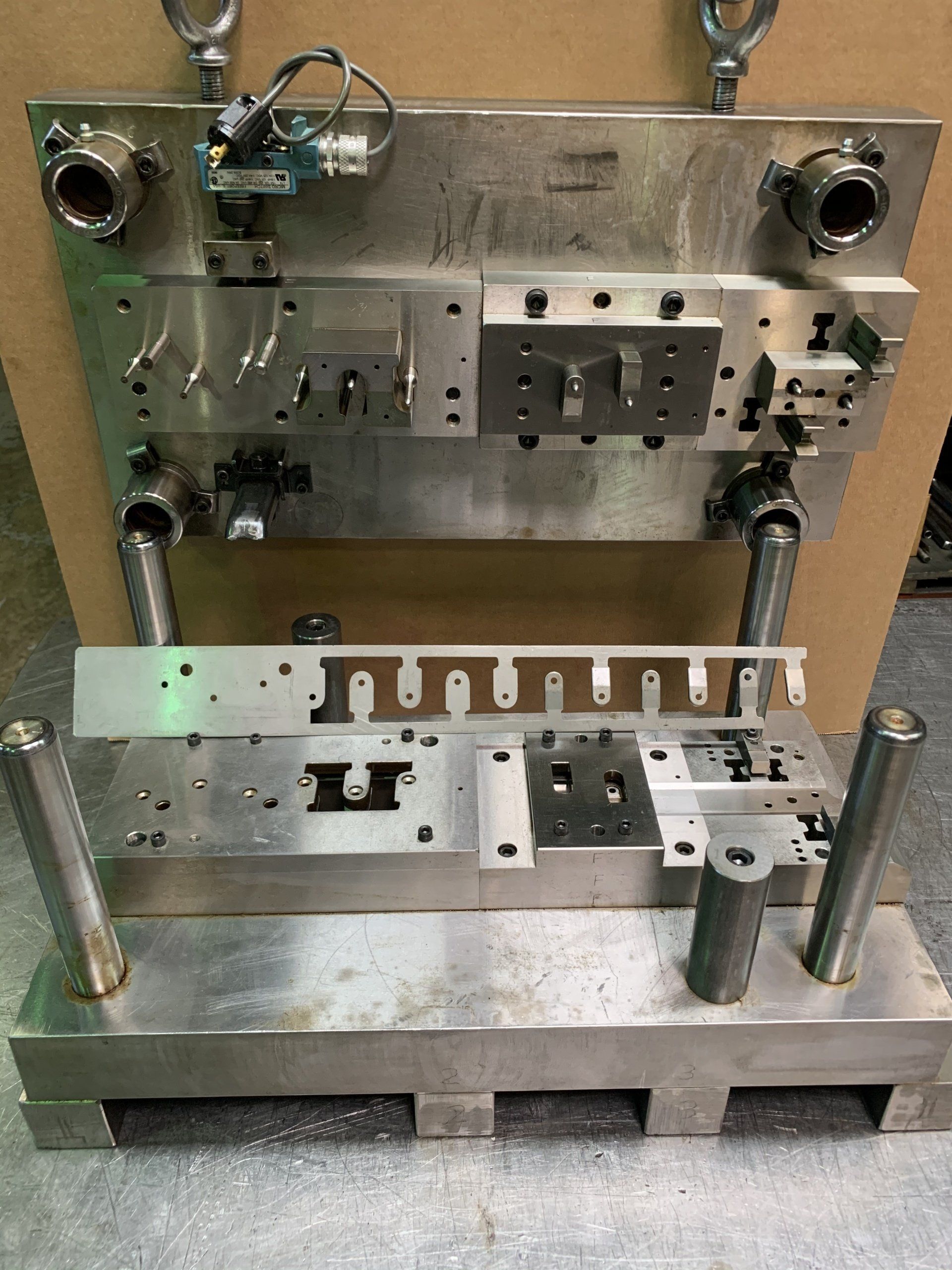 A metal machine is sitting on top of a wooden pallet.